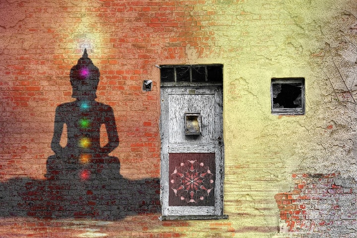 shadow with 7 chakras on wall beside a battered wooden door